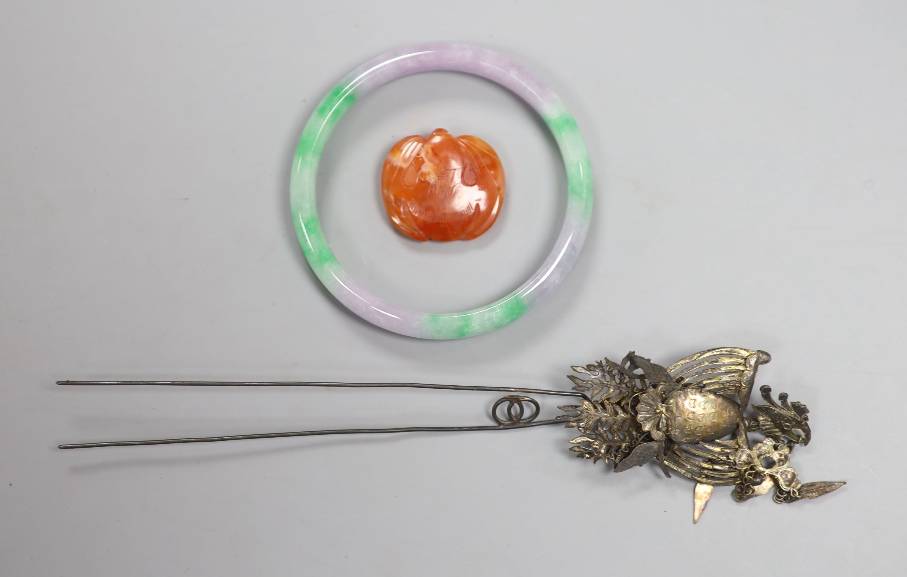 A Chinese late Qing white metal hairpin, 20cm, a jadeite bangle and a chalcedony carving